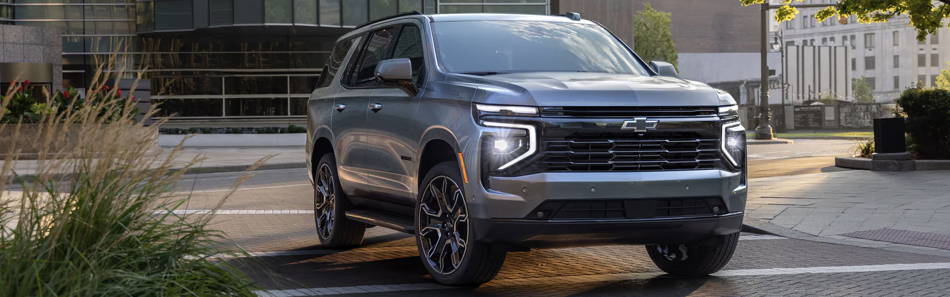 2025 Chevrolet Tahoe full-size SUV in metallic gray styling in an urban setting.